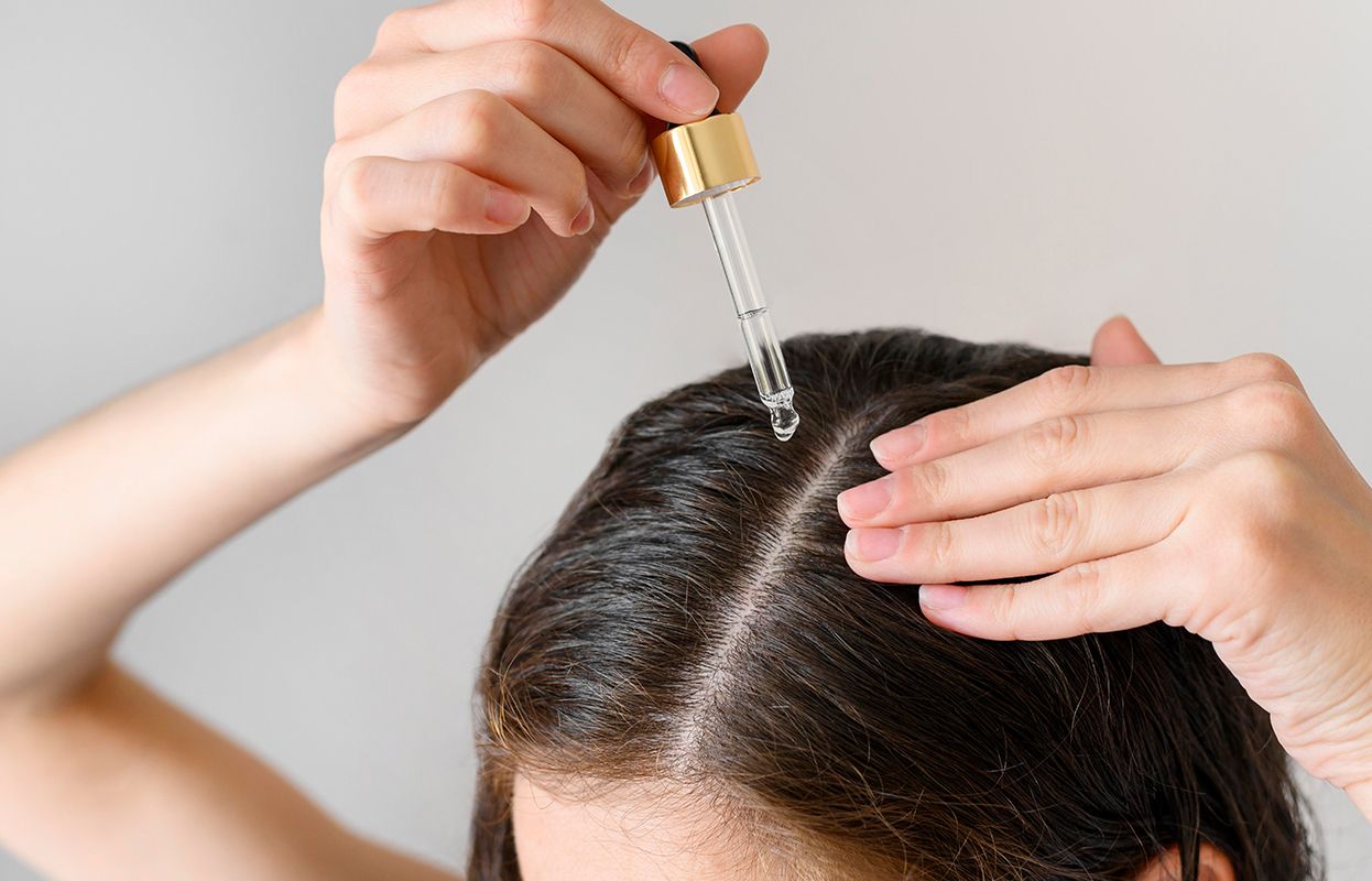 Woman applying hair oil
