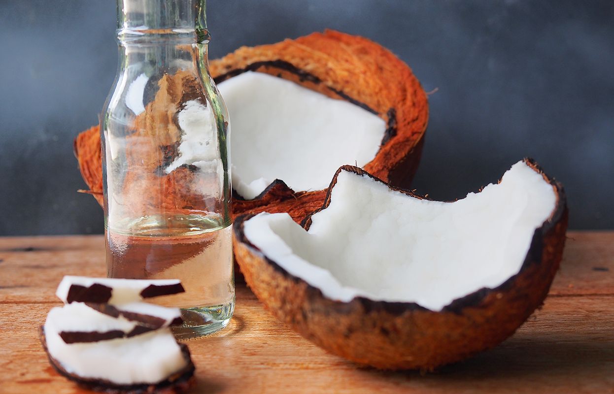 Broken coconuts with an unmarked jar of oil