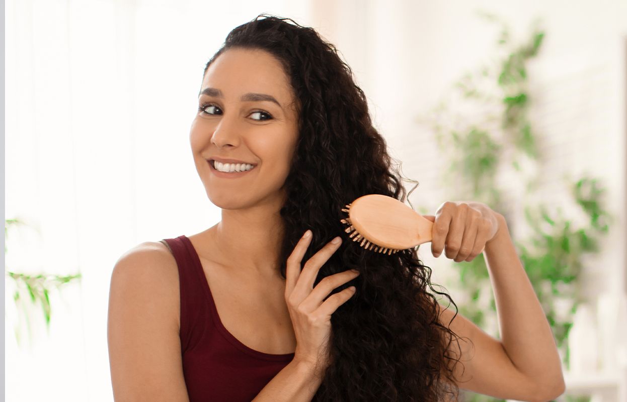 A woman with curly hair pampering her hair