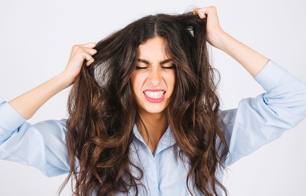 A Woman Irritated with a dry scalp and hair