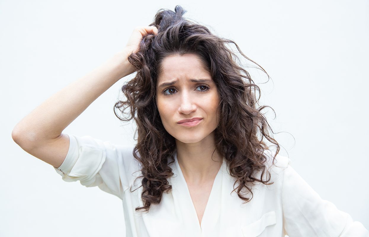 Irritated woman with dry hair and itchy scalp