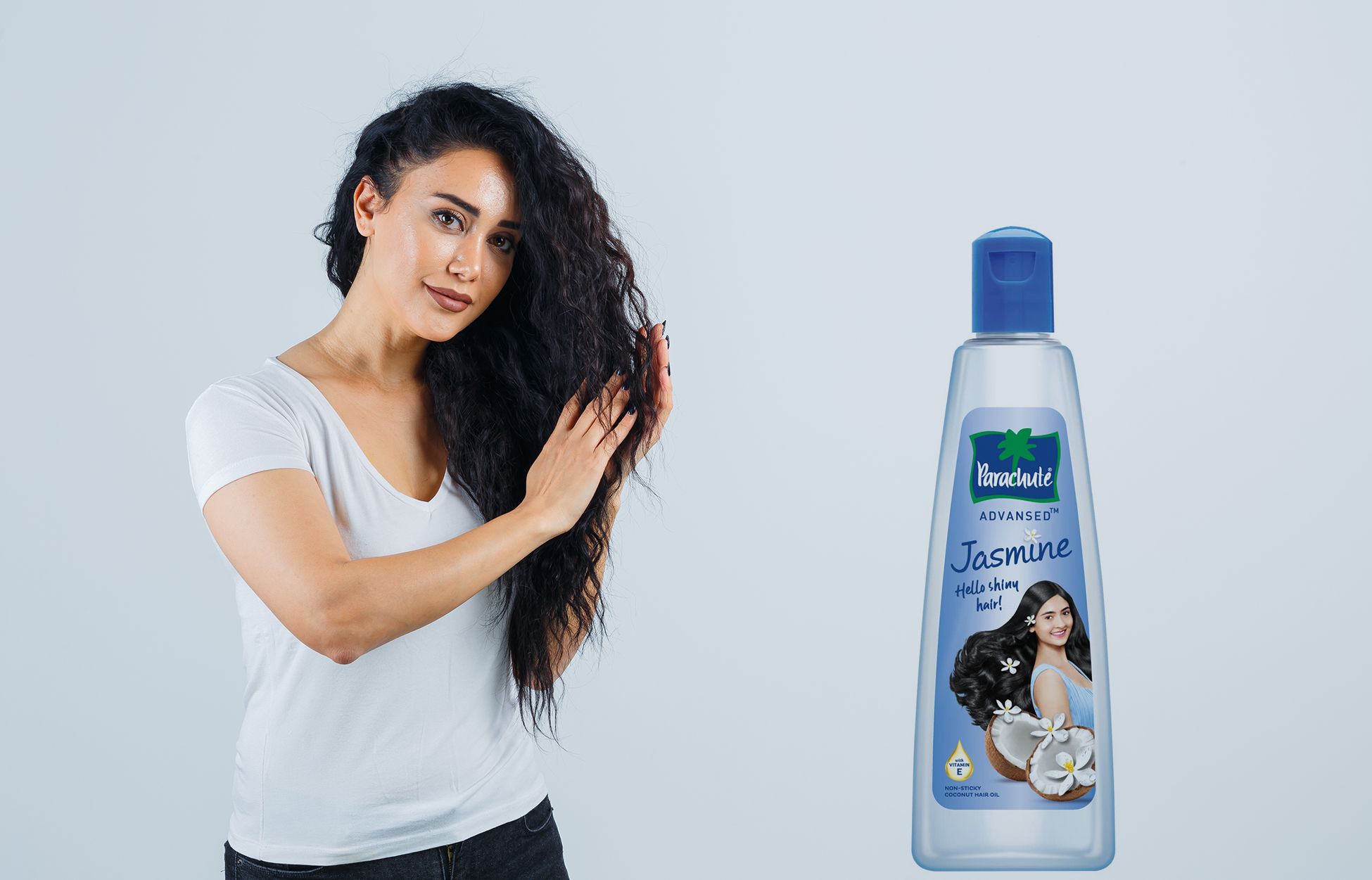 A happy woman oiling her hair with Parachute Advansed Jasmine Hair Oil